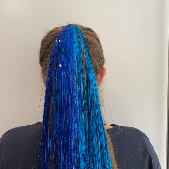 Girl wearing royal blue hair tinsel - 48 inches long and comes in a pack of 120 strands. Its easy really.