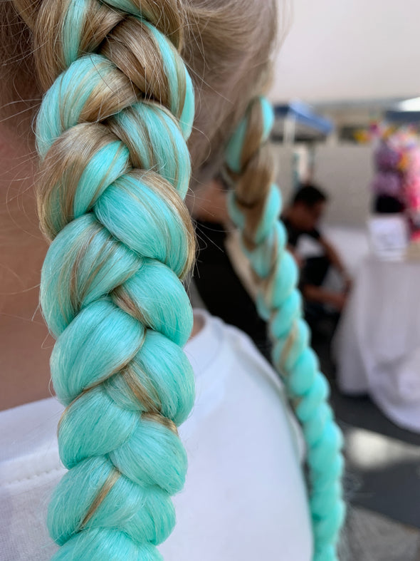 Girl wearing jumbo hair braid - Glow in the dark - spearmint. Each strand is 48 inches long. As a braid it is 24 inches long.