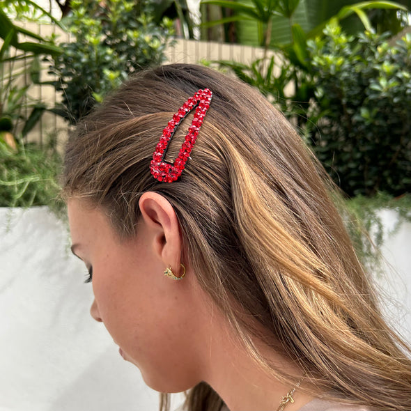 Girl wearing red crystal hair clip set on a well-made sturdy back.