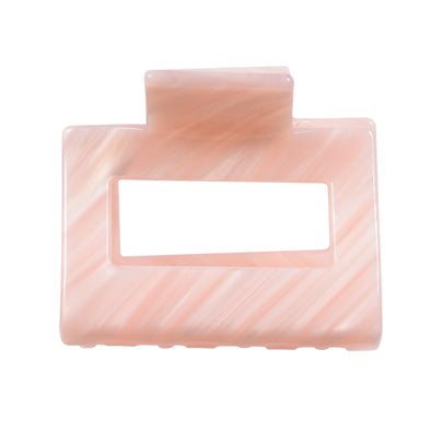 Image of small square hair claw in peach on white background.