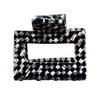 Image of black and white check pattern (domino) small square hair claw on white background