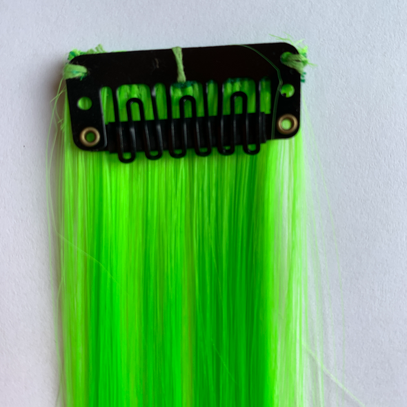Clip in fluro green hair extension. Measurements: 50cm x 3.5cm. Soft synthetic fibre hair.