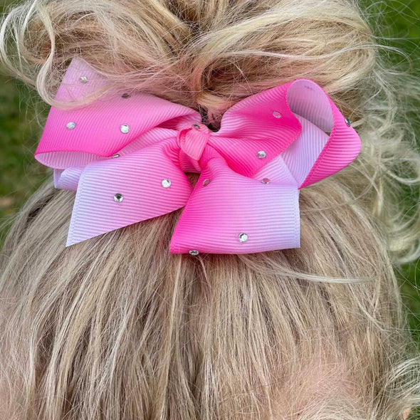 Girl wearing pink ombre diamante bow made from grosgrain ribbon.