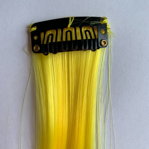 Clip in yellow hair extension. Measurements: 50cm x 3.5cm.  Soft synthetic fibre hair.