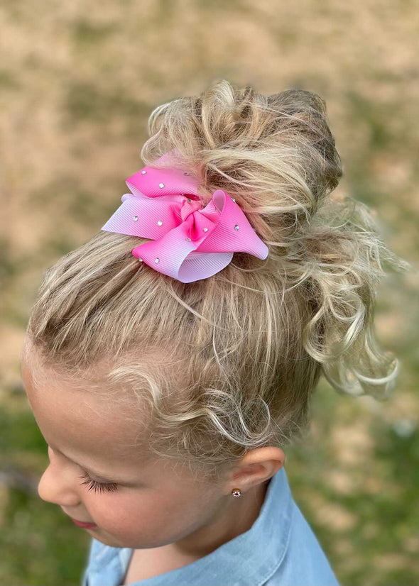 Girl wearing pink ombre diamante bow made from grosgrain ribbon.
