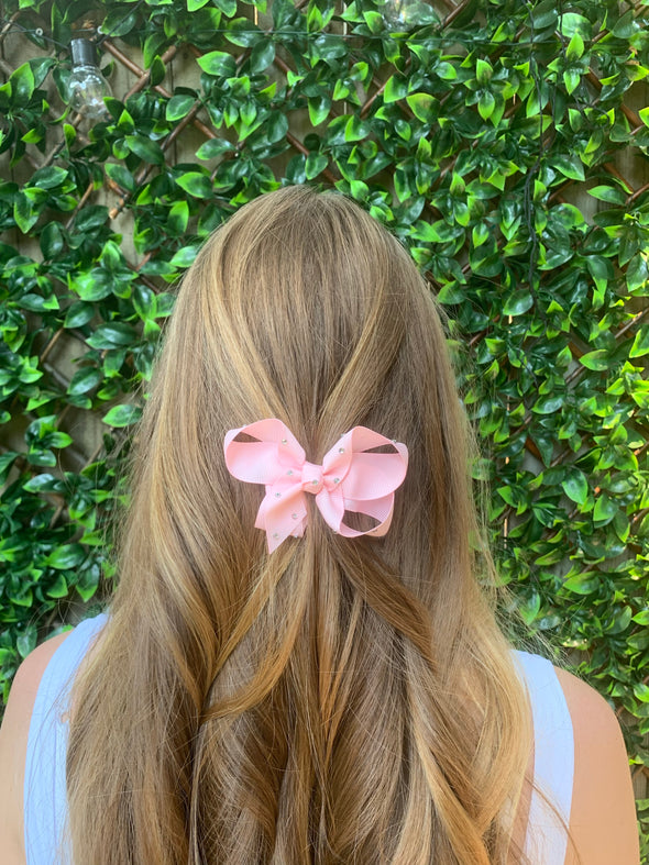 Girl wearing pink diamonte bow.