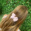 Girl wearing pale pink bow made with grosgrain material.