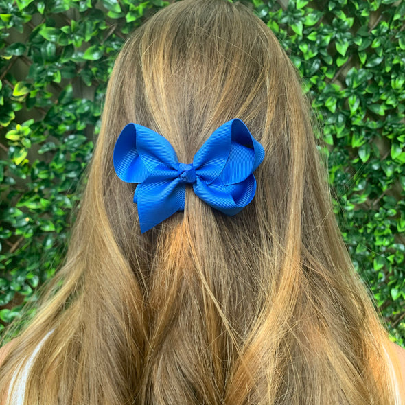 Girl wearing royal blue bow. Size: 100mm x 80mm (approx 3 1/2 inches). Ribbon width: 37mm.