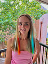 Girl wearing clip in hair extensions in blue, red and green.