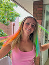 Girl wearing hair extensions in a variety of colours - blue, green, orange and red.