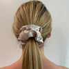 Girl wearing silk Scrunchie - Champagne. Colour/Pattern: Champagne Material: 100% Mulberry Silk. Dimensions: Material width approximately 4 cm. Made by us in Bondi Beach.