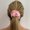 Girl wearing Pink - Melamelon Scrunchie. Colour/Pattern: Pink with pink watermelons (this is also available in yellow). Material: Cotton polyester blend. Dimensions: Material width approximately 4cm. Made by us in Bondi Beach.