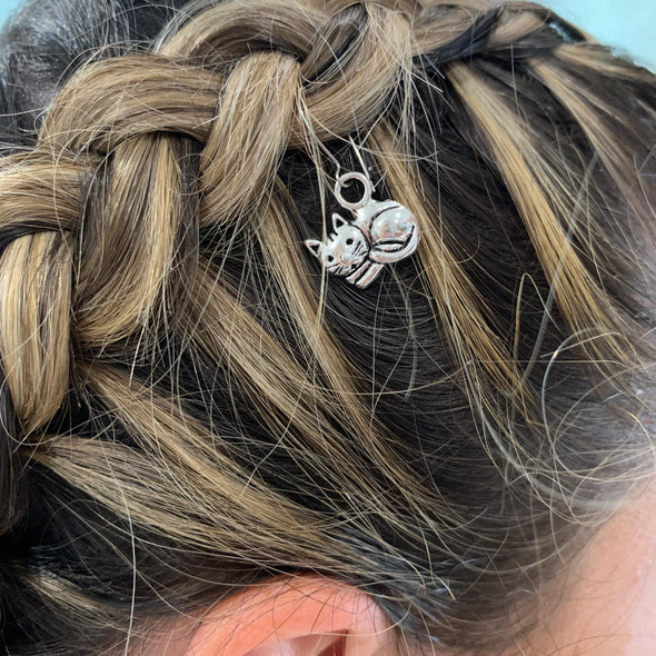 Girl wearing cat charm/hair charm in silver colour (hook included).  Dimensions: 19mm x 9mm.  Material: Charm - zinc alloy, lead free. Hooks: surgical steel.