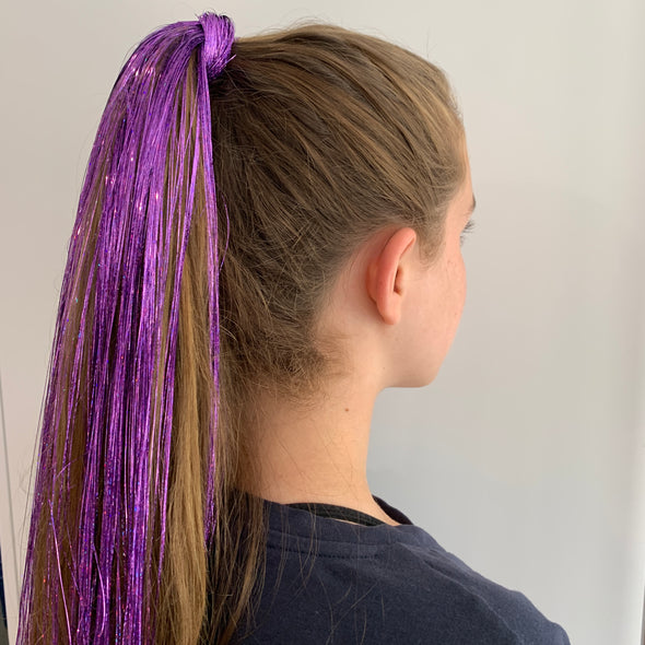 Girl wearing purple hair tinsel - 48 inches long and comes in a pack of 120 strands.