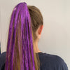 Girl wearing purple hair tinsel - 48 inches long and comes in a pack of 120 strands.