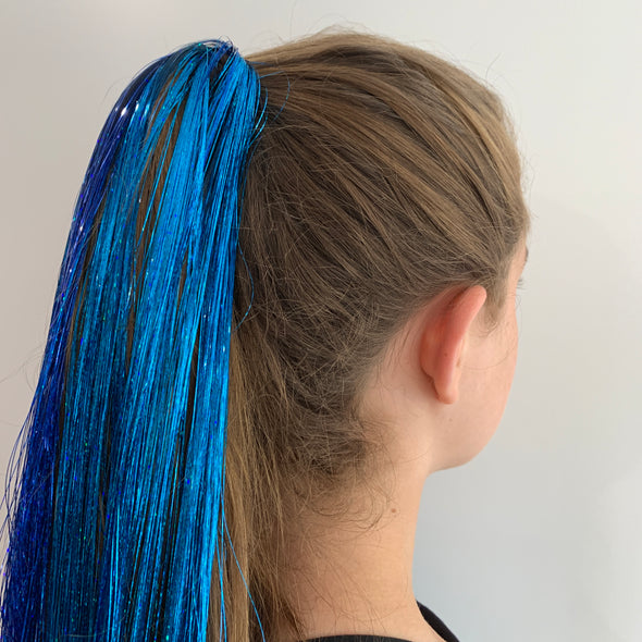 Girl wearing royal blue hair tinsel - 48 inches long and comes in a pack of 120 strands.