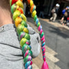 Girl wearing jumbo hair braid in pink rainbow.