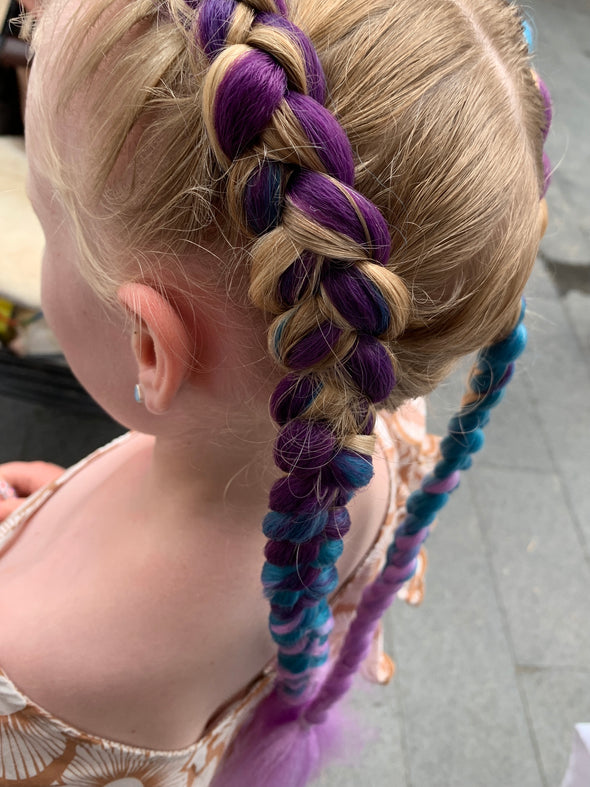 Girl wearing jumbo hair braid in lilac, teal & dark purple. Measurements: Each strand is 48 inches long.