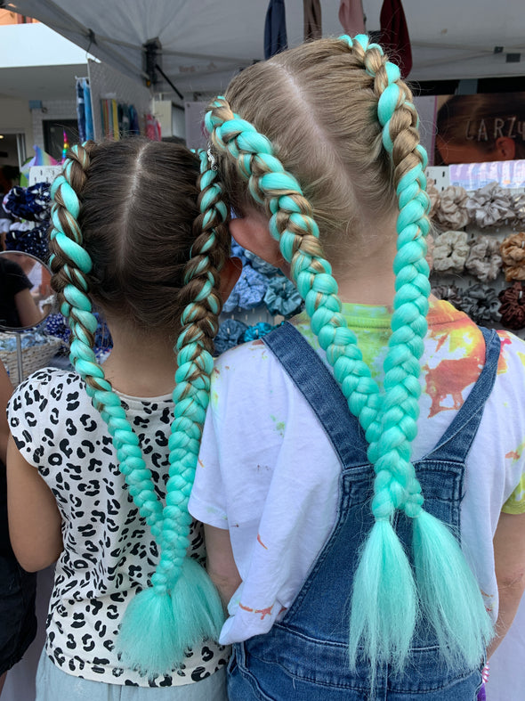 Girls wearing jumbo hair braid - Glow in the dark - spearmint. Each strand is 48 inches long. As a braid it is 24 inches long.