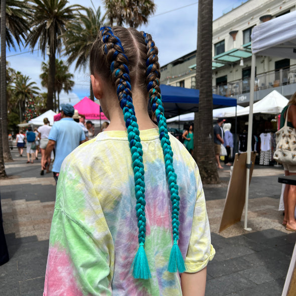 Girl wearing jumbo hair braid in navy and sea green.