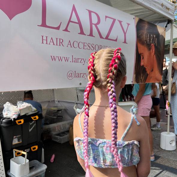 Girl wearing jumbo hair braid in fuchsia, purple and pink.