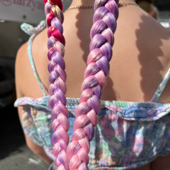 Girl wearing jumbo hair braid in fuchsia, purple and pink.